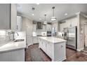 Bright kitchen features white cabinets, stainless steel appliances, large island, and hardwood floors at 1644 Fishbone Dr, Johns Island, SC 29455