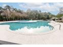 Large community pool surrounded by a concrete deck with lounge chairs, tables, and a view of the trees and neighboring homes at 173 Cypress Forest Dr, Moncks Corner, SC 29461