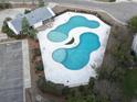 Aerial view of the uniquely shaped community pool and amenity center, surrounded by lush landscaping and a spacious parking lot at 173 Cypress Forest Dr, Moncks Corner, SC 29461