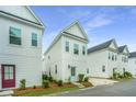 New construction with light colored siding, black roof, and beautifully manicured landscaping in the front at 2008 Stonebraker Ln, Hanahan, SC 29410