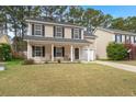 Home with neutral siding, black shutters, covered front porch, and attached garage at 215 Trickle Dr, Summerville, SC 29483