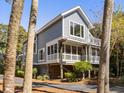 Stylish raised home with a screened porch, lush landscaping, and a walkway winding through the trees at 2202 Oyster Catcher Ct, Seabrook Island, SC 29455