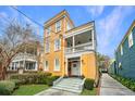 Inviting yellow two-story home featuring a spacious porch and well-manicured lawn at 234 Rutledge Ave # C, Charleston, SC 29403