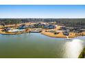 Stunning aerial view of a lakeside community with a pool, tennis courts, and beautifully landscaped grounds at 314 Quiet Cove Trl, Summerville, SC 29486