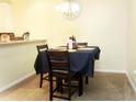 Dining area featuring a square table covered by a dark tablecloth and surrounded by carpeted floors at 3406 Mariners Way, Moncks Corner, SC 29461