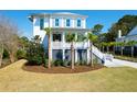 Beautiful two-story beach house with white siding, a charming front porch, and well-manicured lawn at 4176 Victory Pointe Dr, Mount Pleasant, SC 29466