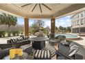 Expansive covered patio with comfortable seating, a cozy fire pit, and views of the lush garden and pool at 4202 Links Ct, North Charleston, SC 29420