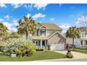 Attractive two-story home with a two-car garage, palm trees, and neatly kept landscaping at 422 Sanders Farm Ln, Charleston, SC 29492