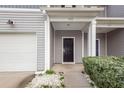 A close-up of the front door of the townhome, set back from the attached garage, with a small stoop at 522 Truman Dr, Goose Creek, SC 29445