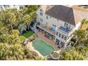 Aerial view of a home featuring a beautiful pool, jacuzzi, deck and lush landscaping at 65 Ocean Point Dr, Isle of Palms, SC 29451