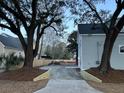 Wide driveway surrounded by trees and landscaping leading up to the side of the home at 651 Magnolia Rd, Charleston, SC 29407