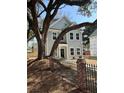 Charming two-story home with new paint, black trim windows, black fence and a beautiful mature tree at 651 Magnolia Rd, Charleston, SC 29407
