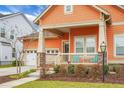 Attractive one-story home with front porch and blue chairs, showcasing meticulous landscaping and a double garage at 729 Quintan St, Summerville, SC 29486