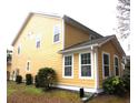 The yellow siding and white trim create a clean, modern look at 8592 Sentry Cir, North Charleston, SC 29420