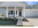 Welcoming home exterior with a covered porch and a two-car garage with a driveway at 87 Morning Song St, Summerville, SC 29485