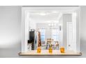 A servery window connects the dining room with chandelier to the kitchen for ease of service at 947 E Estates Blvd # C, Charleston, SC 29414