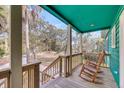 Inviting porch with wooden rocking chairs and a view of the lush surroundings at 1009 Seacrest Ln, Folly Beach, SC 29439