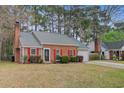 Charming brick home featuring a brick chimney, red shutters, and a tidy front yard at 103 York Pl, Goose Creek, SC 29445