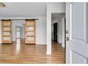 Bright living room with modern sliding barn doors and wood floors offers an open concept feel at 105 Gourdin St, Saint Stephen, SC 29479