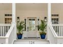 Elegant front entrance with glass-paneled door, stylish sconces, and potted plants, enhancing curb appeal at 124 Beresford Creek St, Charleston, SC 29492