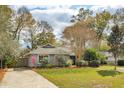Charming single-story home featuring lush lawn, mature trees, and an American flag at 1327 Bob White Dr, Charleston, SC 29412