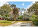 A well-maintained house, with manicured lawn, mature trees, and a long concrete driveway at 1327 Bob White Dr, Charleston, SC 29412