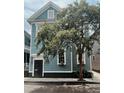 Charming blue home with black shutters, flowering tree and manicured garden at 157 Tradd St, Charleston, SC 29401