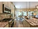 Open-concept kitchen features stainless appliances, granite counters, and sight lines to dining area at 170 Collared Dove Ct, Summerville, SC 29483