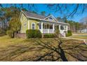 Inviting exterior with a classic covered porch, lush greenery, and well-maintained landscaping at 2101 Heavens Way, Summerville, SC 29483