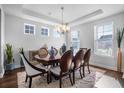 Elegant dining room featuring large windows, a modern chandelier, and an ornate table set for six at 242 Bering Ln, Summerville, SC 29486