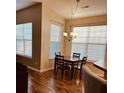 Cozy dining area featuring a modern chandelier, hardwood floors, and large windows for natural light at 2598 Spivey Ct, North Charleston, SC 29406