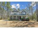 Charming two-story home with gray siding, stone accents, manicured lawn, and inviting front porch at 3000 Flat Rock Ln, Ridgeville, SC 29472