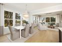 Bright dining area flowing into a living space with hardwood floors and oversized windows at 377 Blowing Fresh Dr, Charleston, SC 29492