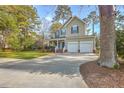 Charming two-story home with a inviting front porch, a well-kept lawn, a driveway and an attached two car garage at 401 Waring St, Summerville, SC 29483