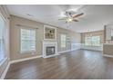 Spacious living room with a fireplace, ceiling fan, beautiful hardwood floors, neutral colored walls, and natural light at 401 Waring St, Summerville, SC 29483