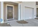 Close up of the front entrance, garage, and ADT security system of the townhome at 4678 Palm View Cir, North Charleston, SC 29418