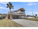 Inviting elevated beach house with multiple decks, screened porch, and ample ground-level parking at 601 Pompano Rd, Edisto Island, SC 29438