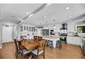 Open kitchen and dining area with white cabinets, stainless appliances, central island and wood dining table at 601 Pompano Rd, Edisto Island, SC 29438