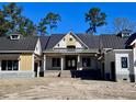 A charming new construction home with a dark metal roof and two-tone yellow and white siding at 3945 Bulow Landing Rd, Hollywood, SC 29470