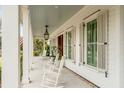 Relaxing front porch with white rocking chairs and a view of the lush greenery surrounding the property at 1010 Tall Pine Rd, Mount Pleasant, SC 29464