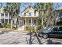 Charming two-story home with front porch and lush landscaping, featuring palm trees and a classic architectural style at 102 Barnaby St, Charleston, SC 29492