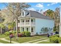 Inviting two-story home with a double porch, surrounded by a well-maintained lawn at 1300 Carol Oaks Dr, Mount Pleasant, SC 29466