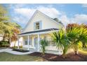 Charming yellow two-story home with a cozy front porch and lush landscaping at 1412 Sandstone Pl, Charleston, SC 29492