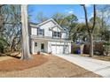 Inviting two-story home, surrounded by trees, features a quaint entry and concrete driveway at 1630 Balsam St, Charleston, SC 29407
