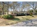Brick single-story home featuring mature trees and colorful landscaping at 1929 Westminster Rd, Charleston, SC 29407