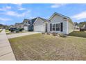 Charming gray one story home showcasing a well-manicured front yard and attached garage at 1941 Zonny Moss Dr, Johns Island, SC 29455