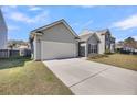 View of gray home featuring an attached garage, driveway, and well-maintained landscaping at 1941 Zonny Moss Dr, Johns Island, SC 29455