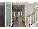 Bright foyer with wood floors, white staircase, and view into the living area with water views at 217 Denham St, Summerville, SC 29486