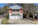 Exterior view of a two-story home with a garage and a unique deck, surrounded by lush greenery at 247 Lotz Dr, Summerville, SC 29483
