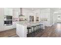 Bright kitchen with stainless steel appliances, large island with seating and hardwood flooring at 318 Archar St, Summerville, SC 29486